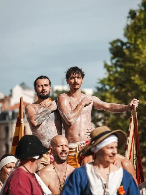 Les compagnons de Lioussac dans une foule costumée, deux d’entre eux couverts de mousse